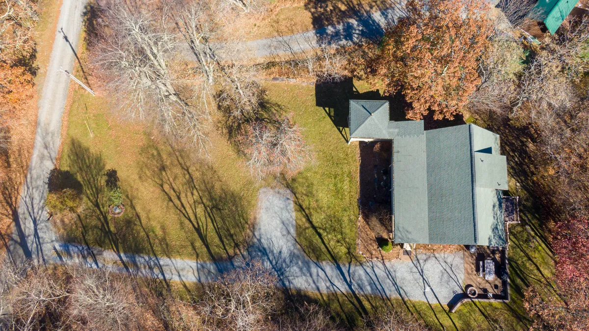An exterior view of the house with a semi-flat yard and surrounding trees. The open space is ideal for children and pets to play safely, perfectly echoing the section’s emphasis on the expansive, pet-friendly yard.