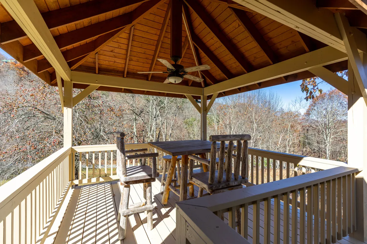 The image spotlights the rustic wooden gazebo furnished for comfort, surrounded by lush nature. It invites thoughts of outdoor dining, morning coffee, or evening gatherings, while highlighting the connection to the mountain landscape and the tranquil atmosphere promised in the section.